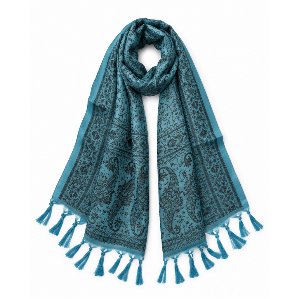 A teal blue scarf with a black paisley and floral pattern, featuring tassel fringe on both ends, displayed against a solid white background.