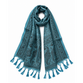 A teal blue scarf with a black paisley and floral pattern, featuring tassel fringe on both ends, displayed against a solid white background.