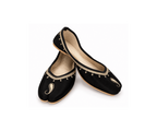 A pair of black velvet traditional flat shoes with gold embroidered details and a split toe design, displayed on a clean white background.