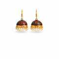 A pair of traditional Indian jhumka earrings with gold-plated hooks and frames, featuring a deep red and green floral enamel dome and dangling white pearl beads, shown on a plain white background.