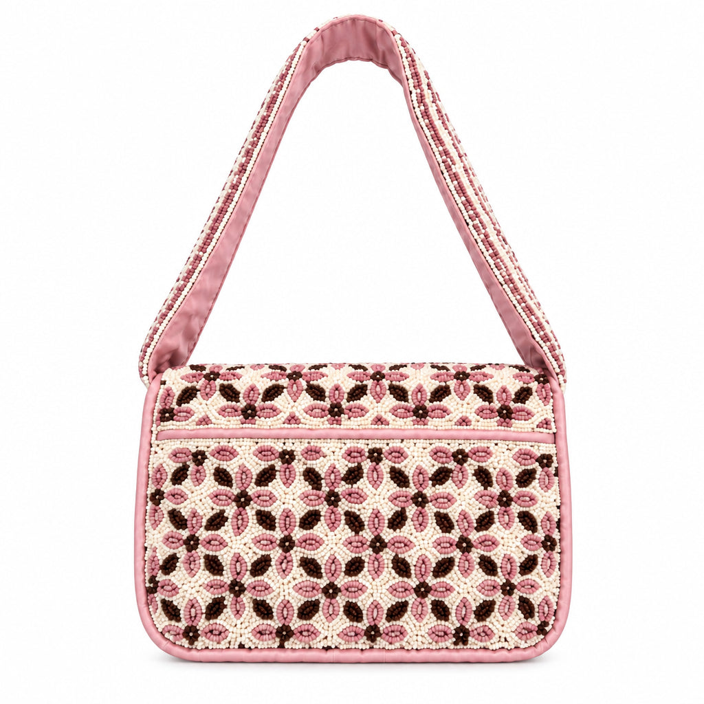 A small rectangular handbag with a pink and black patterned fabric body and a pink strap, photographed from above on a plain off-white background.