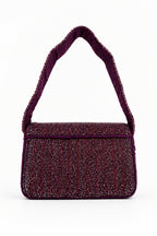 A small rectangular shoulder bag with a textured, shimmering burgundy body and a matching wide shoulder strap, shown on a plain white background.