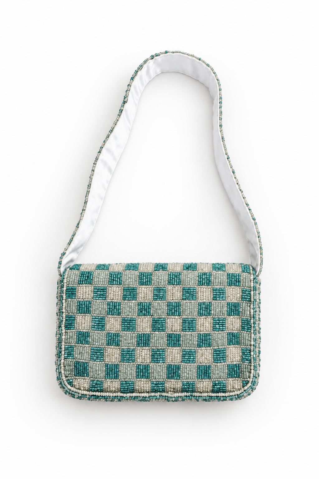 A small fabric shoulder bag with a blue and beige checkered patterned body and a white fabric strap, laid flat on a light beige surface.