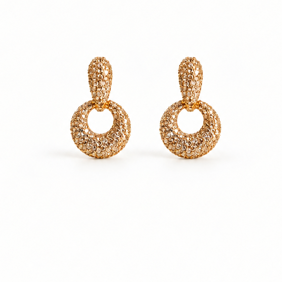 A pair of gold-toned dangle earrings covered in pavé-set clear stones, shown on a clean white background.