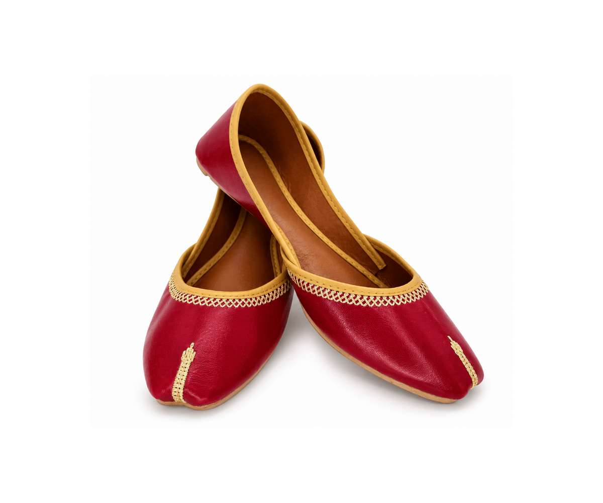 A pair of traditional red leather Juttis with gold embroidery and trim, displayed on a clean white background.