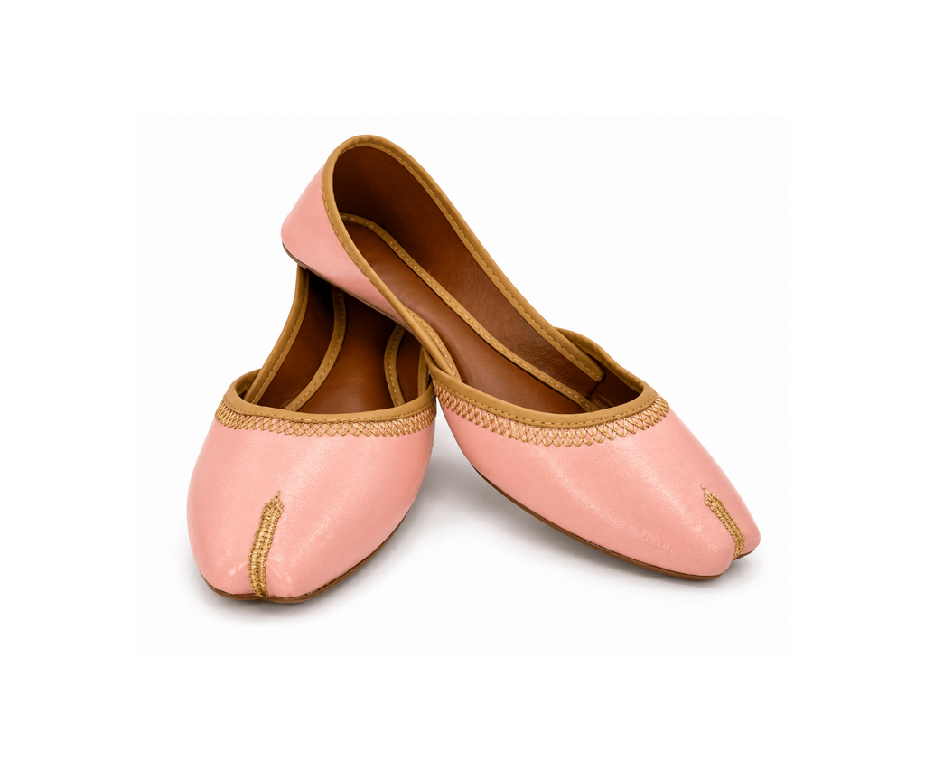 A pair of light pink leather flat shoes with gold embroidery and a traditional pointed toe, displayed on a clean white background.